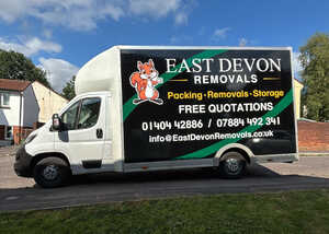 White removal truck with "East Devon Removals" branding parked on a residential street.