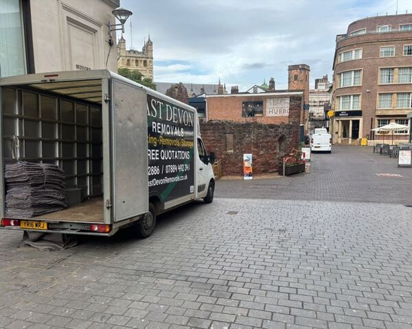 East Devon Removals van parked outside the Princesshay building in central Exeter, with period buildings visible in the background