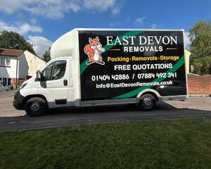 A removal truck with "East Devon Removals" branding parked on a residential street.