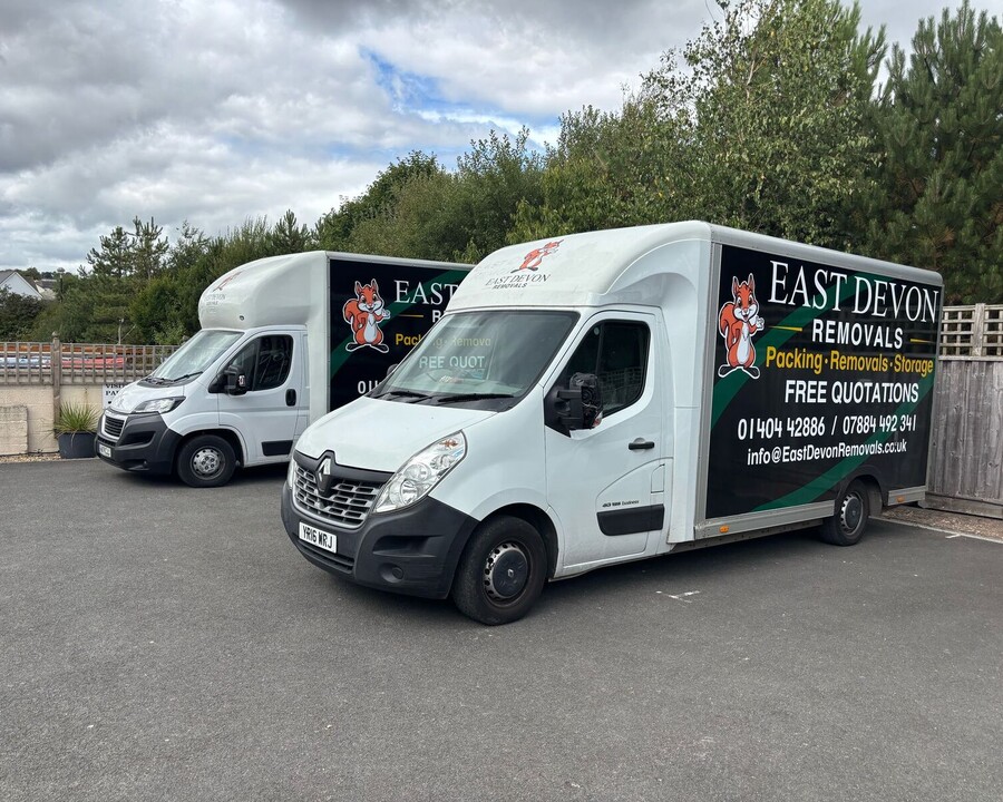 A removal truck with "East Devon Removals" branding parked on a residential street.